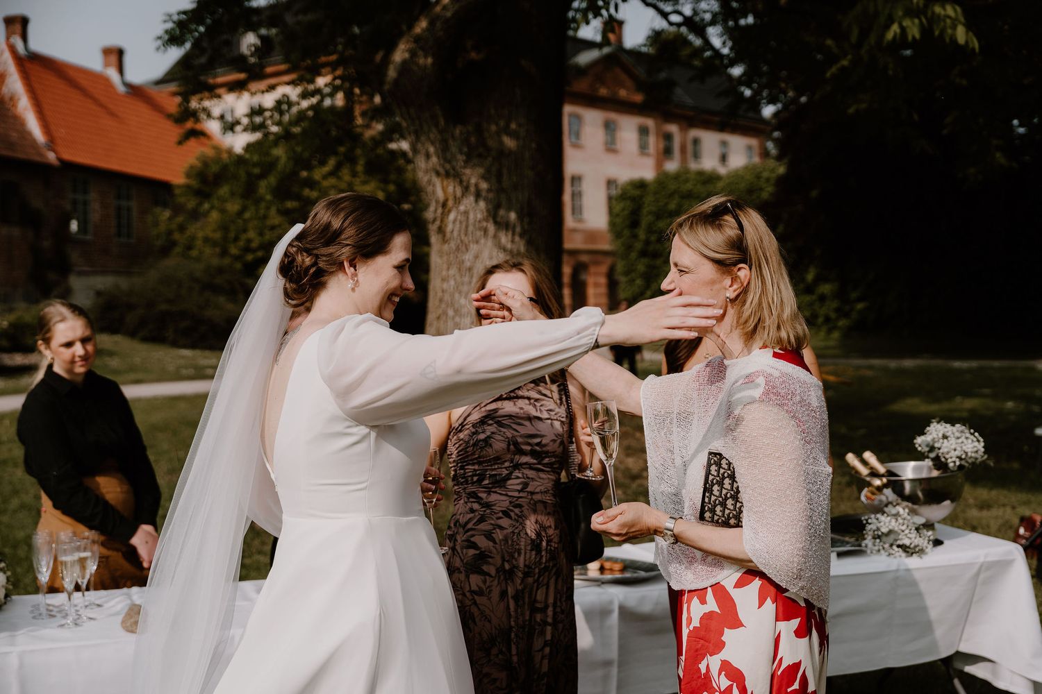 A joyful bridal party walks together outdoors smiling and laughing during an autumn outdoor photo session.