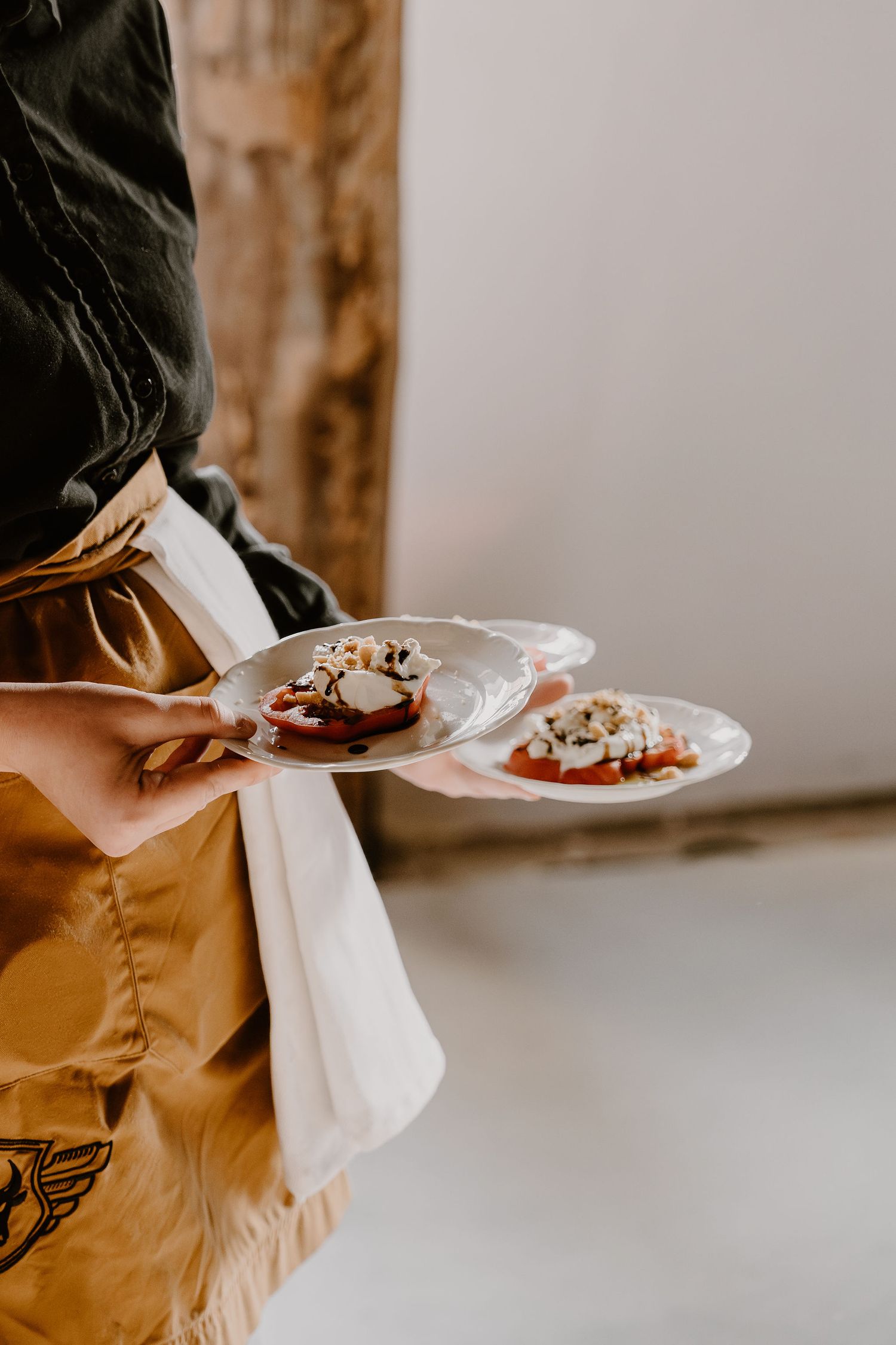Multiple hands holding small white plates with maroon and brown colored desserts arranged in a sequence.