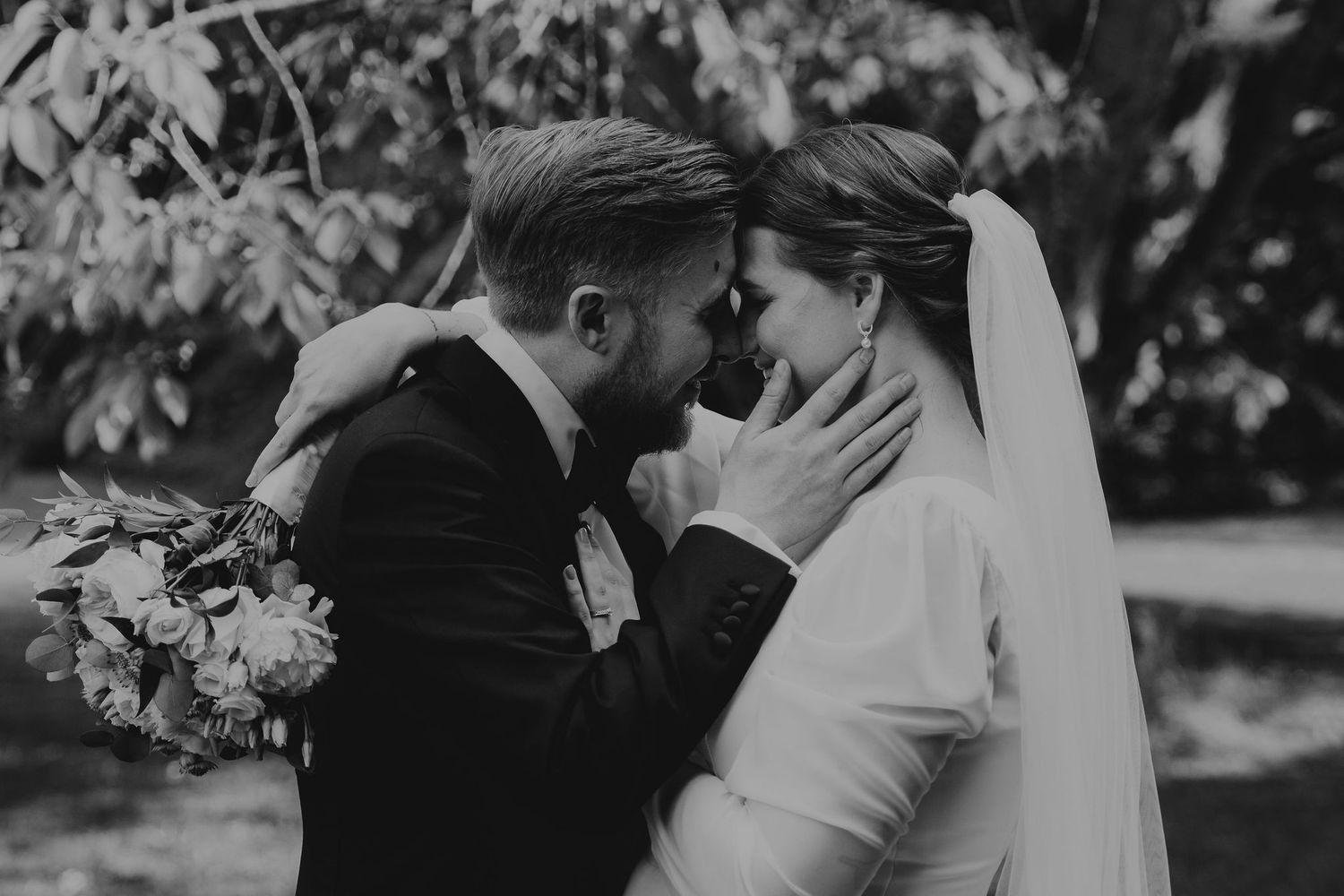 Black and white photo series capturing intimate moments between a bride and groom in an outdoor garden setting.