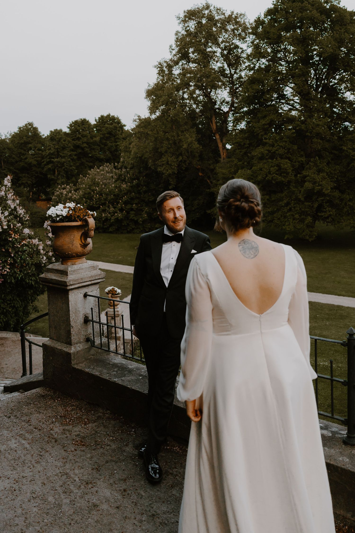 A wedding couple poses together on a garden terrace showcasing romantic and intimate moments at an outdoor venue.