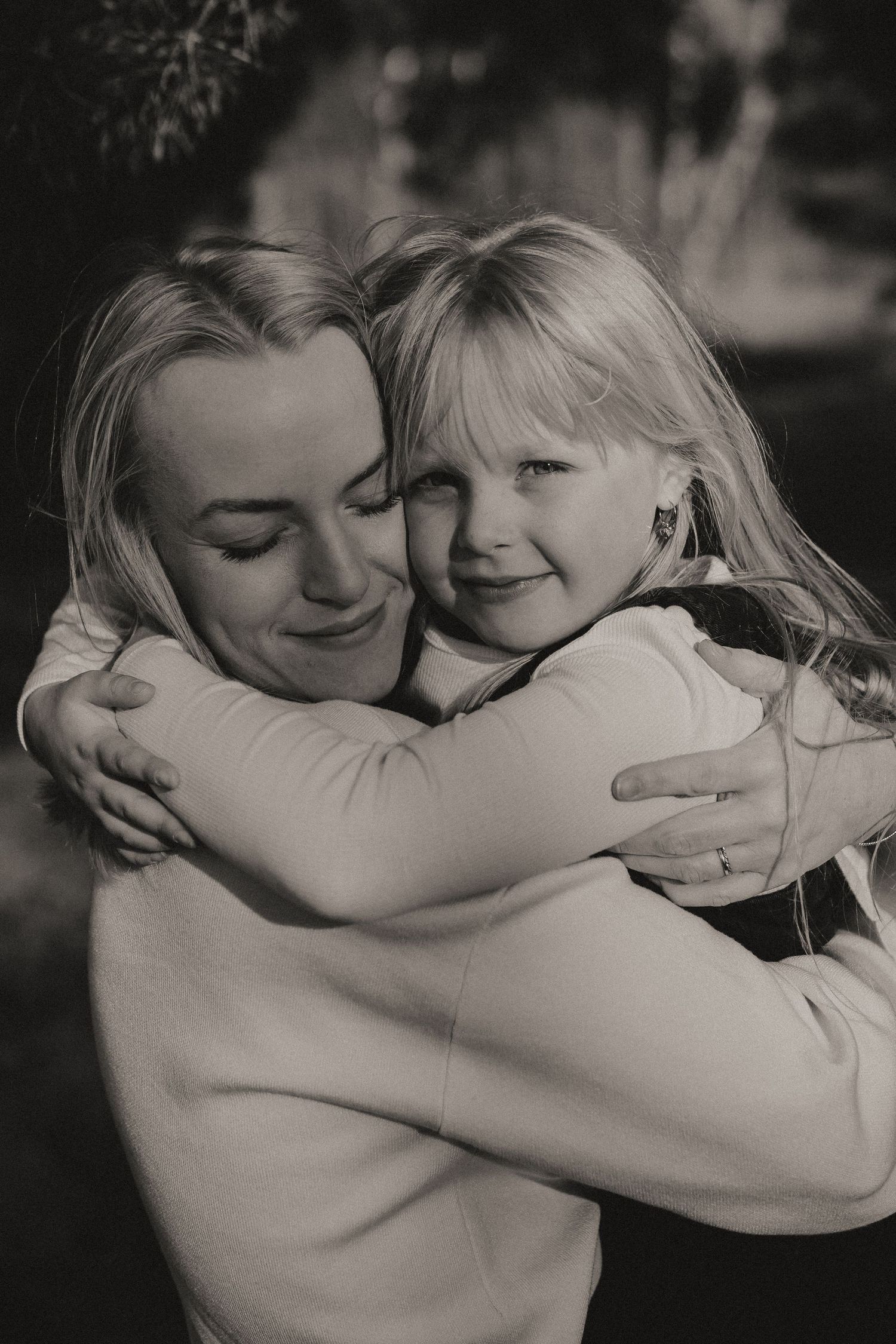 Sweet embrace captured in black and white shows tender moment between parent and child.