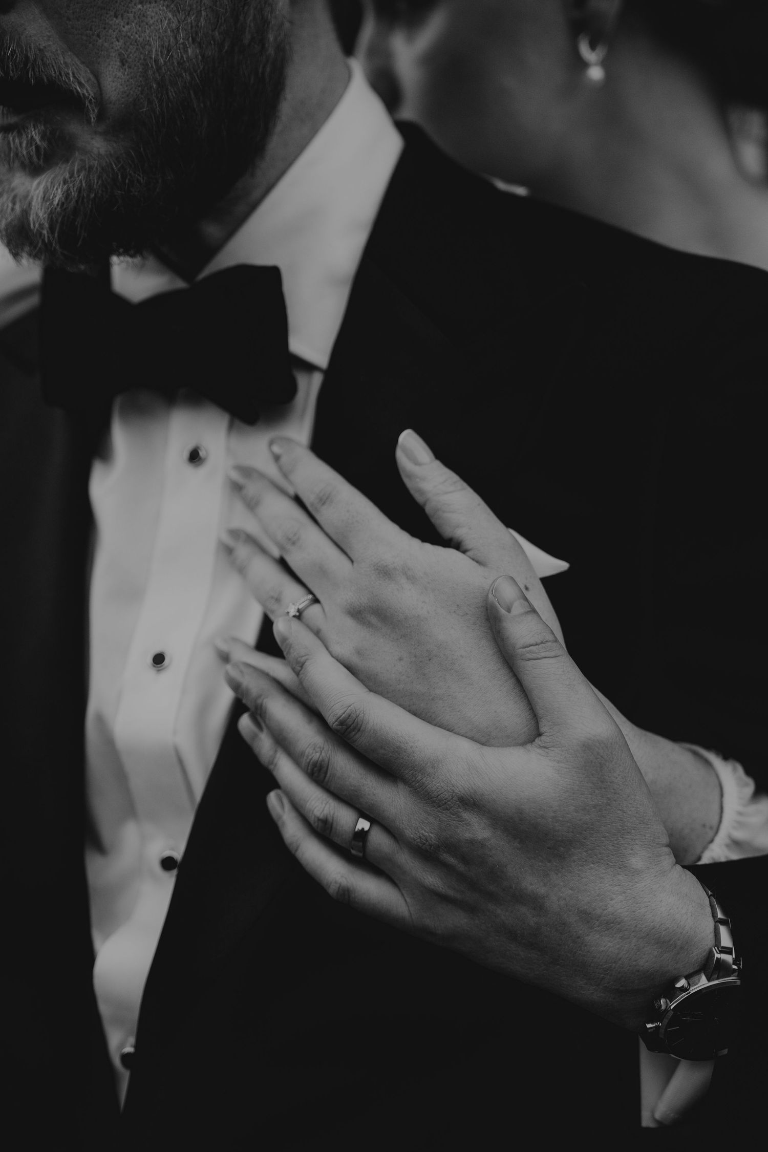 Black and white close-up images showing hands wearing wedding rings in intimate emotional moments at a formal event.