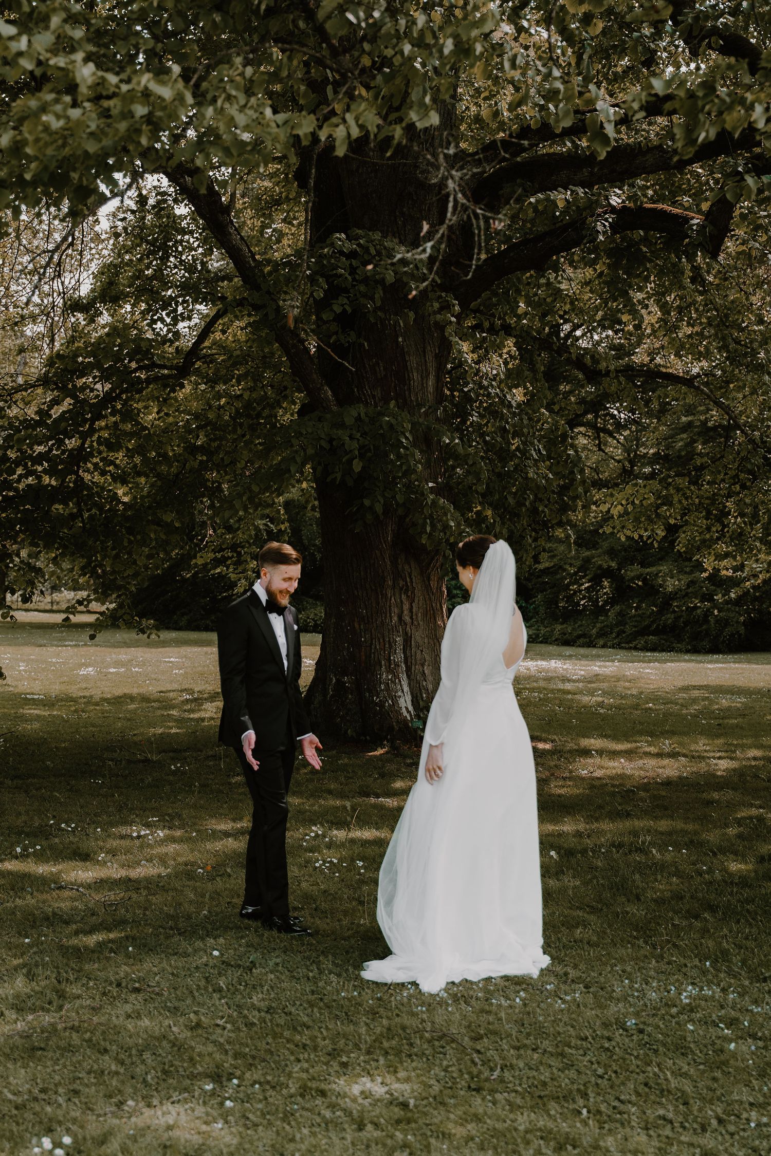 First look moment between a couple during their outdoor wedding as the bride approaches in her flowing white gown.