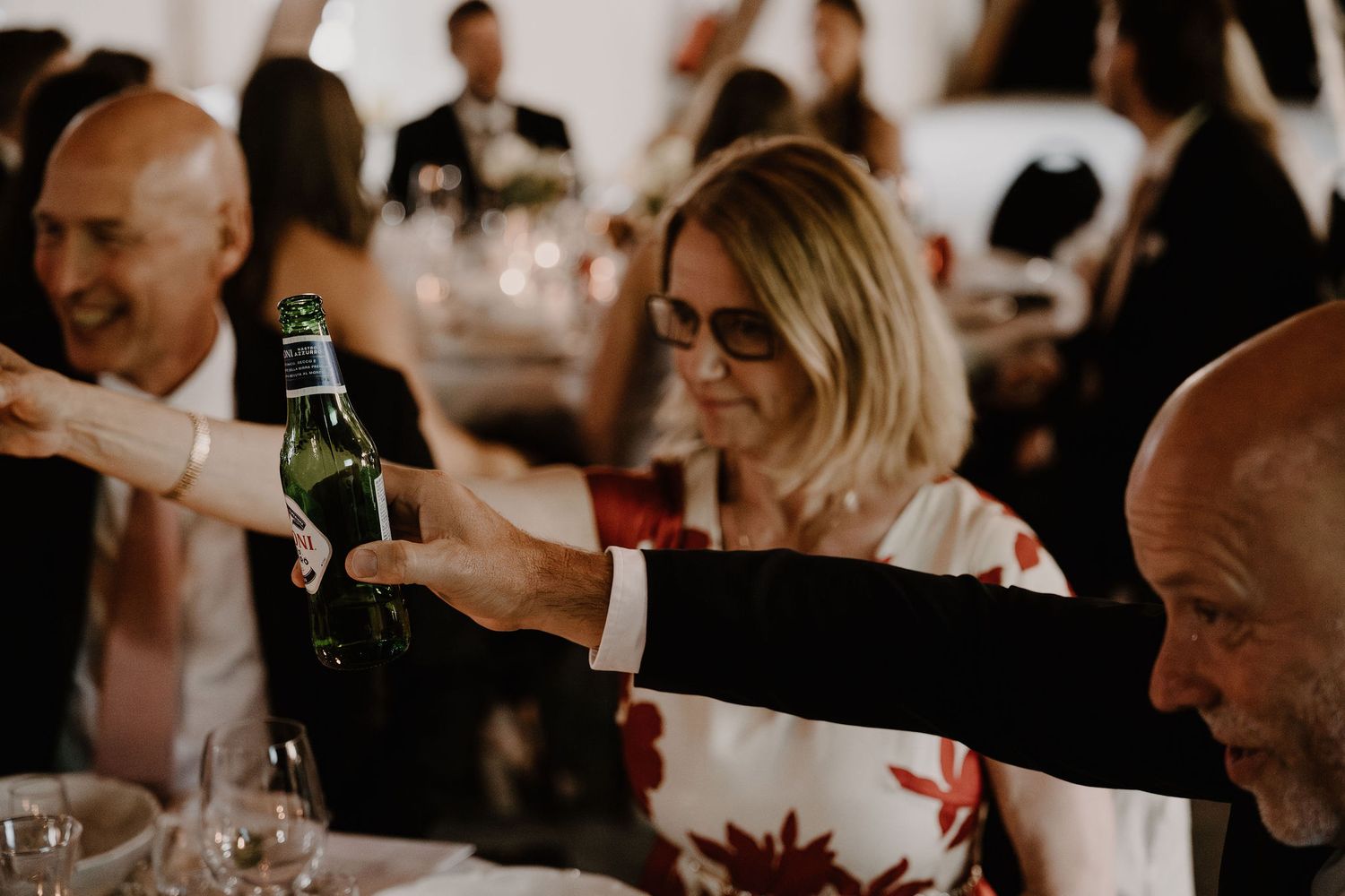 Wedding guests enjoying drinks and dinner at an elegant reception celebration.