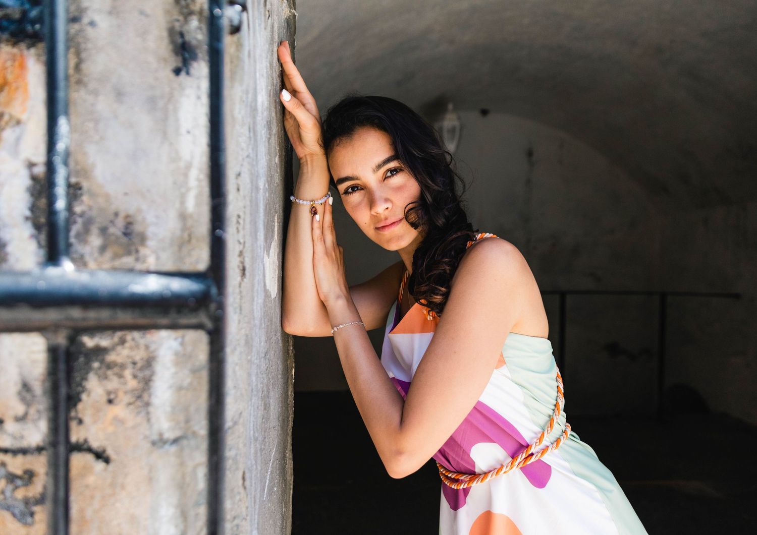 Portrait in a tunnel setting with natural lighting and vintage architectural elements.