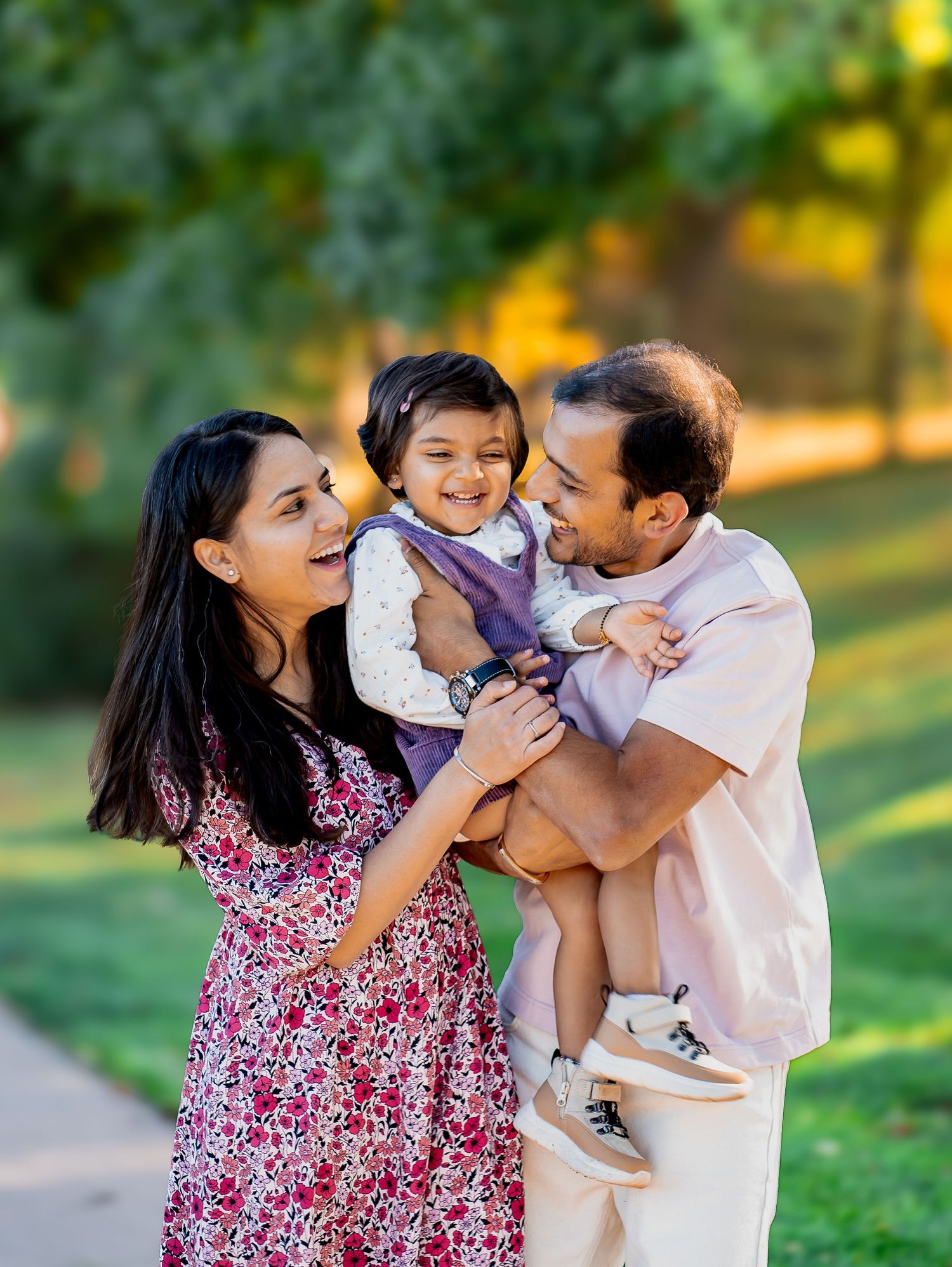 Family shares a joyful moment together in a sunny park setting.