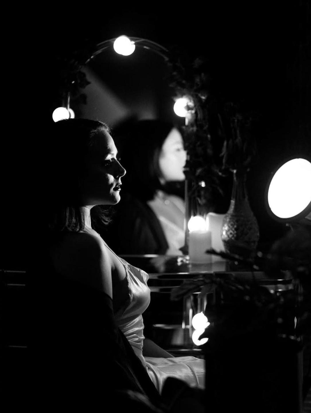 Dramatic black and white portrait with vintage lighting and mirror reflections.