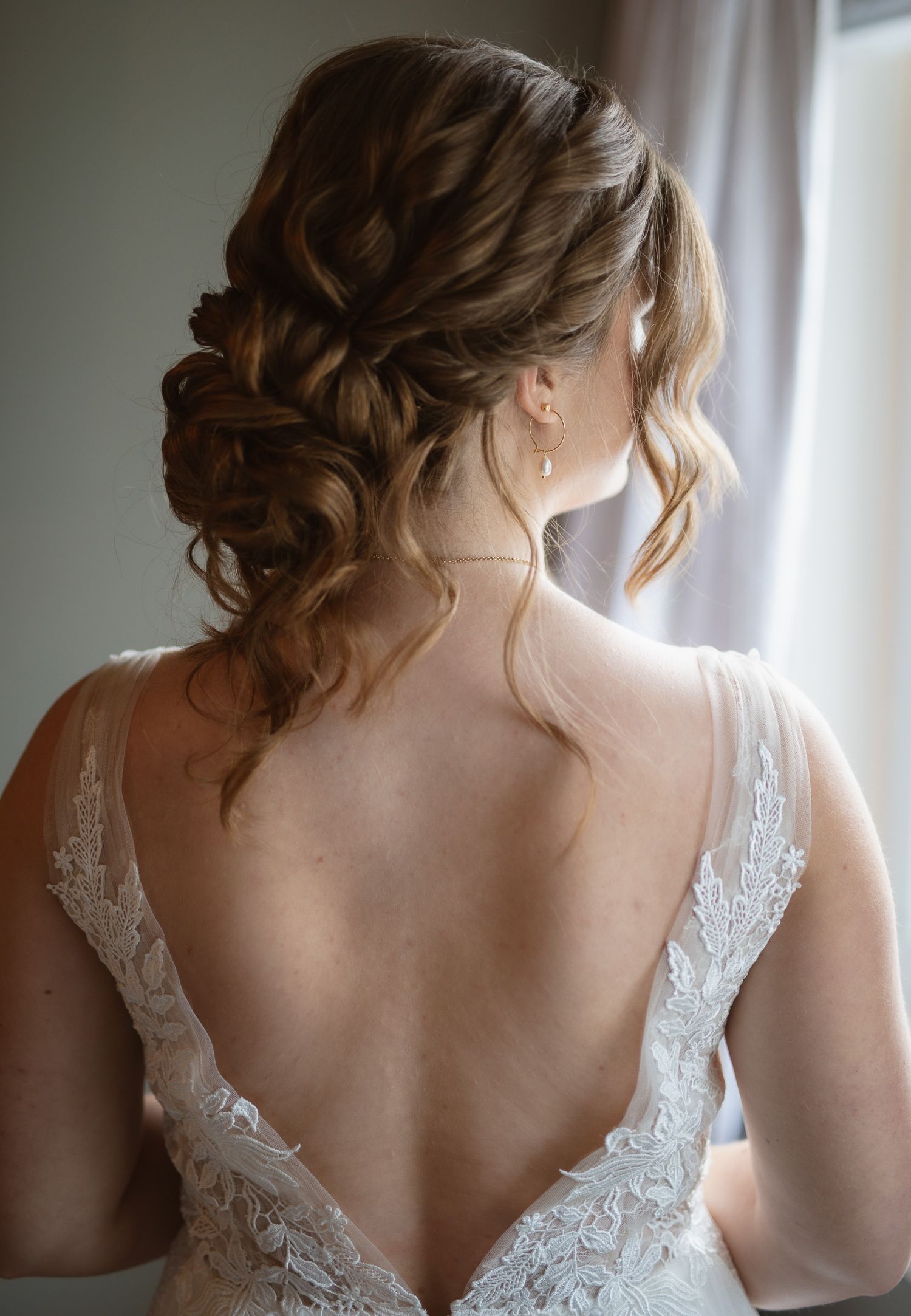 Elegant lace wedding dress detail with delicate shoulder straps and intricate back design.