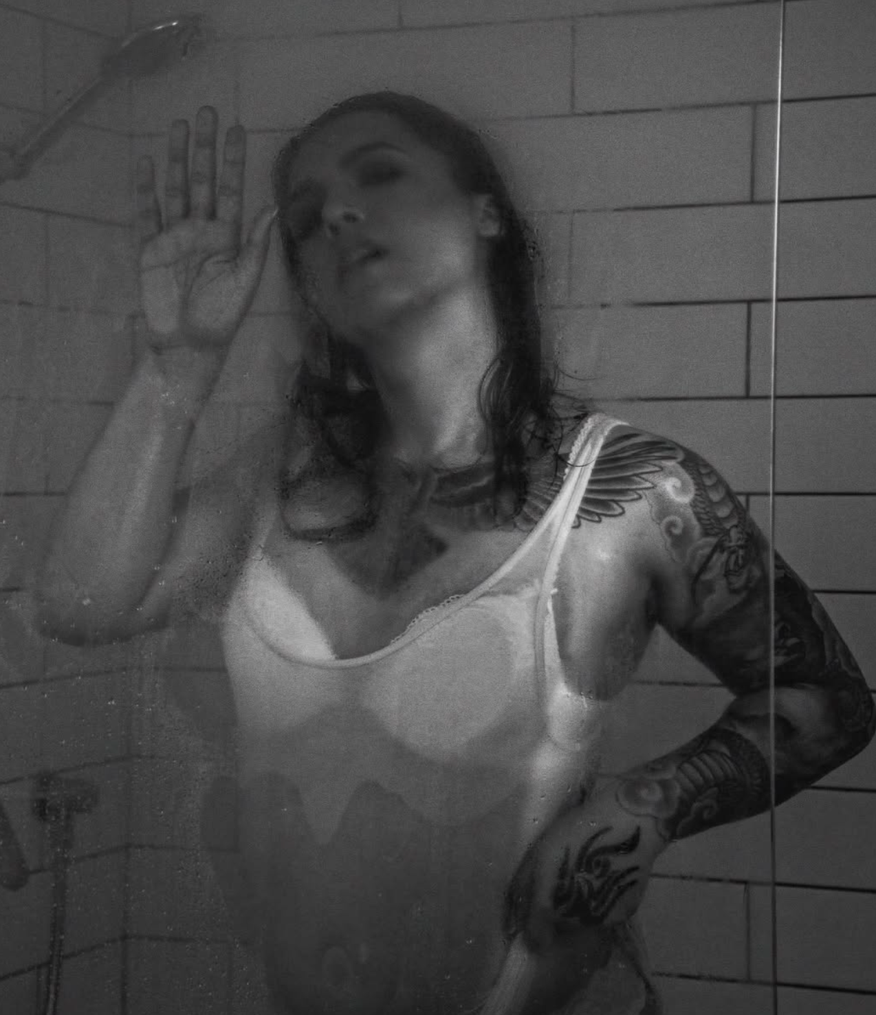 Moody black and white portrait in bathroom with steam and dramatic lighting.