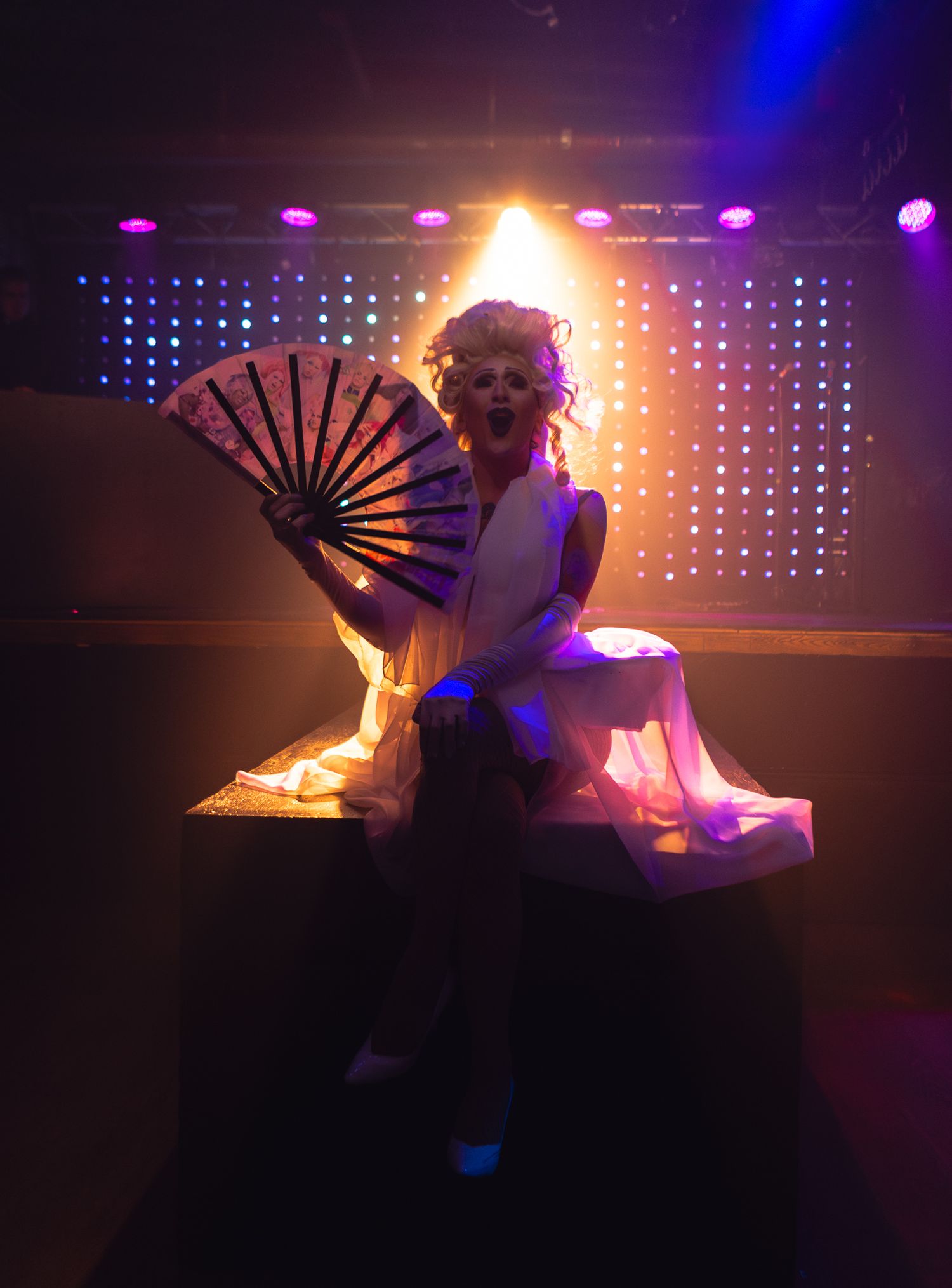 Dramatic performance with fan and lighting effects against LED backdrop.