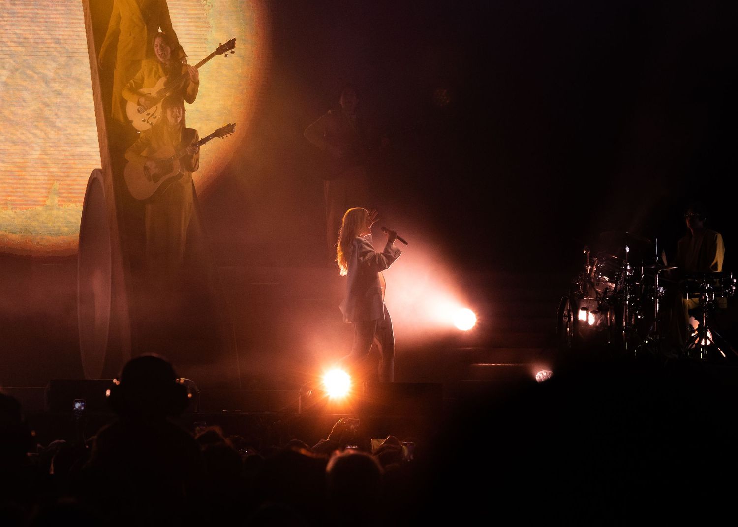 Silhouetted performer on stage illuminated by dramatic orange backlighting during a concert performance.