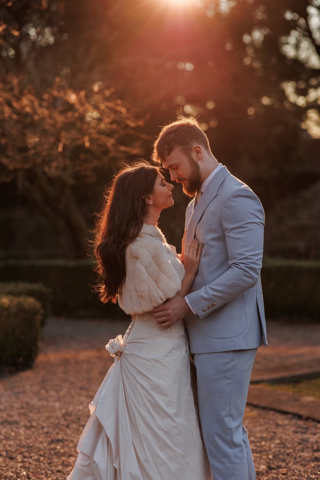 Warm sunset light bathes a romantic moment in an autumn garden setting.