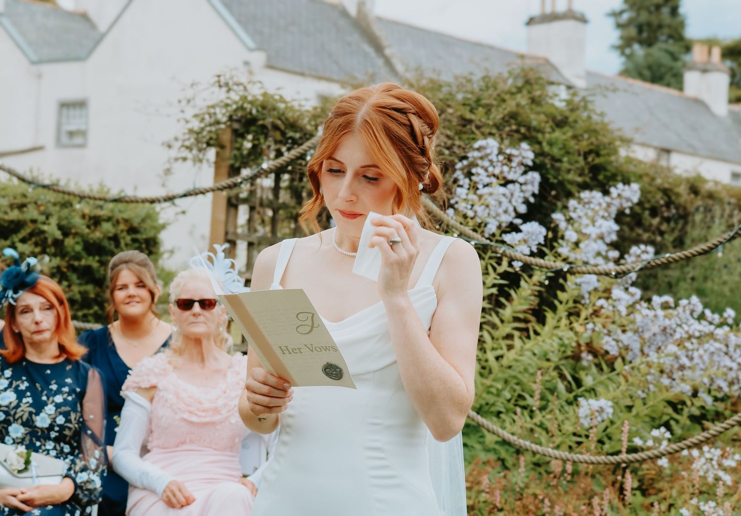 A casual outdoor garden wedding celebration showing a couple with guests dancing, drinking, and enjoying festive moments together.
