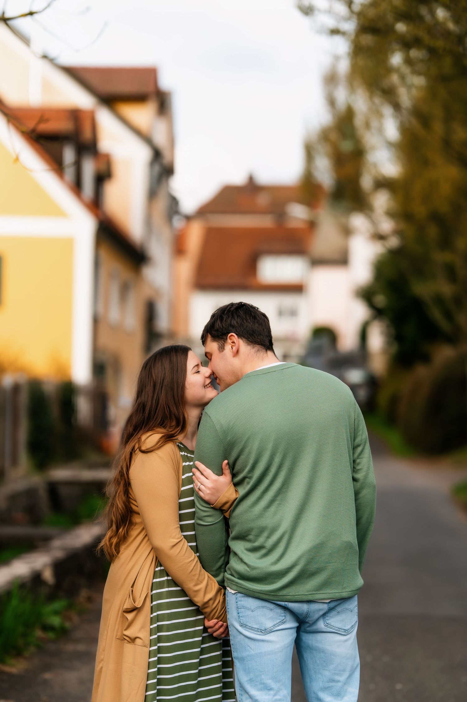 Sweet couple moment captured from behind on residential street.