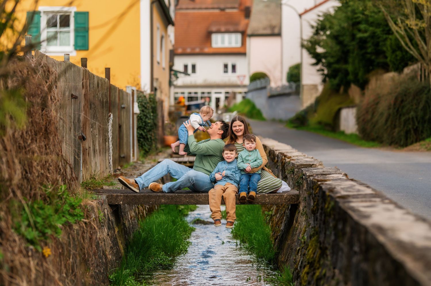 Creative family photo series showing fun poses along suburban sidewalk.