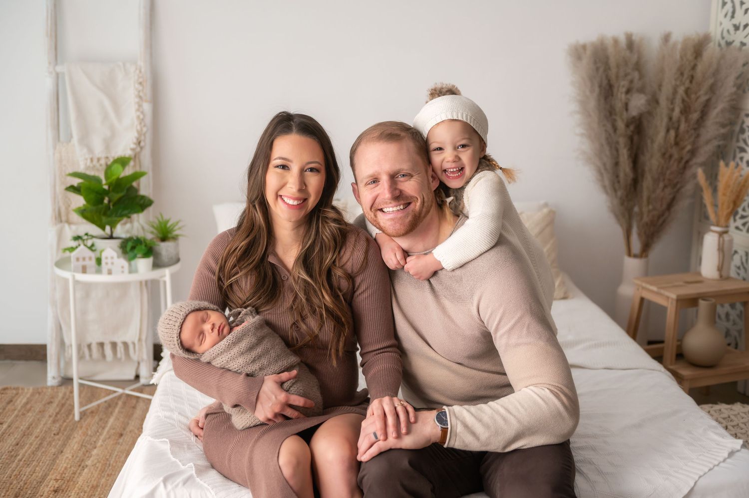 A cozy family portrait in neutral colors against a minimalist home interior.