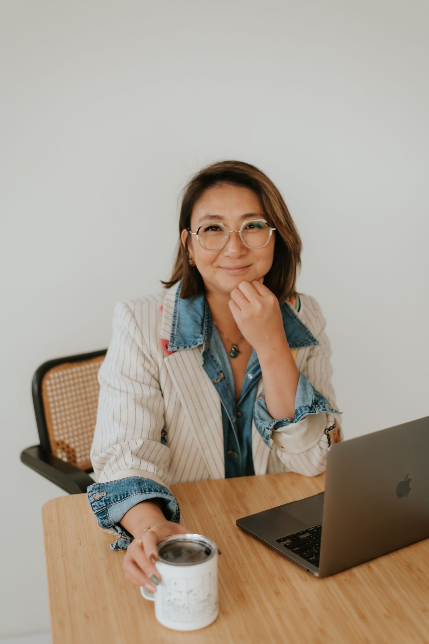 A sequence of photos showing someone working at a wooden desk with a laptop and coffee cup while wearing denim and stripes.