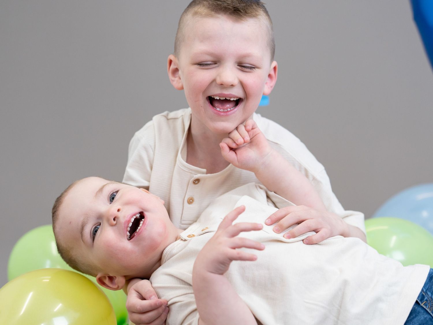A joyful expression spreads across someone's face as they laugh with delight while lying on a soft surface.