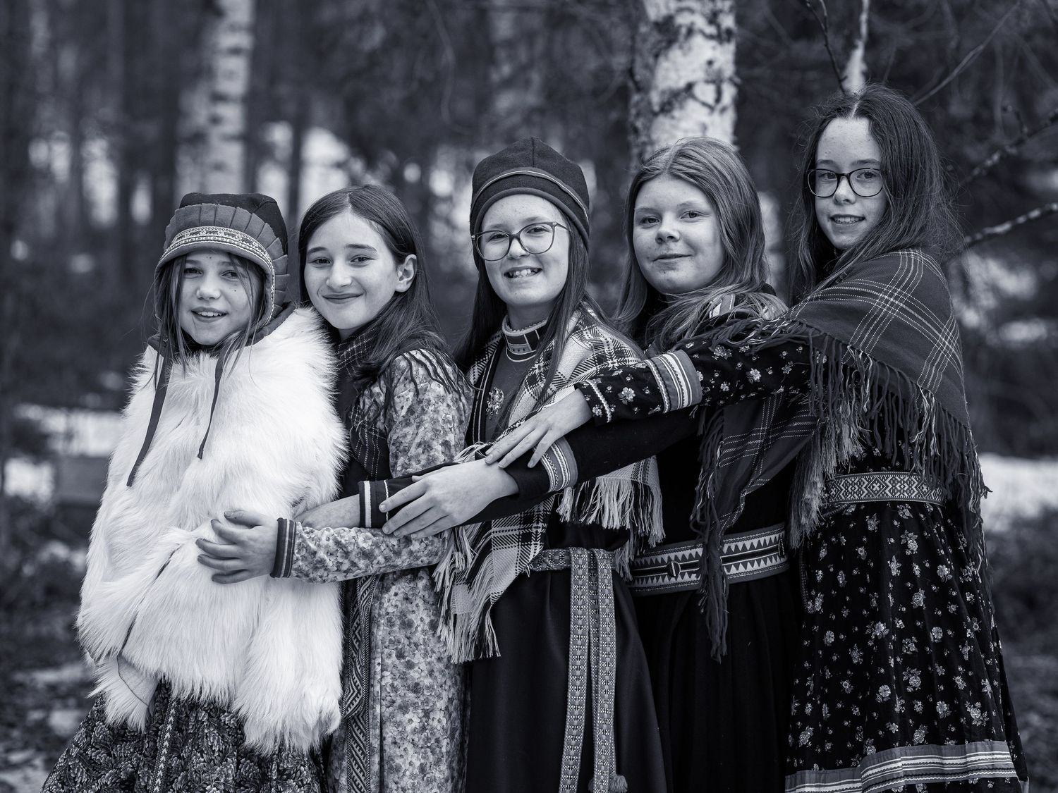 Gruppfoto på fem personer i vinterkläder som står tillsammans i skogsmiljö.