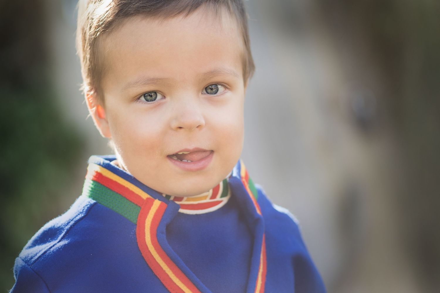 Close-up portrait wearing traditional Sami-inspired rainbow collar garment.