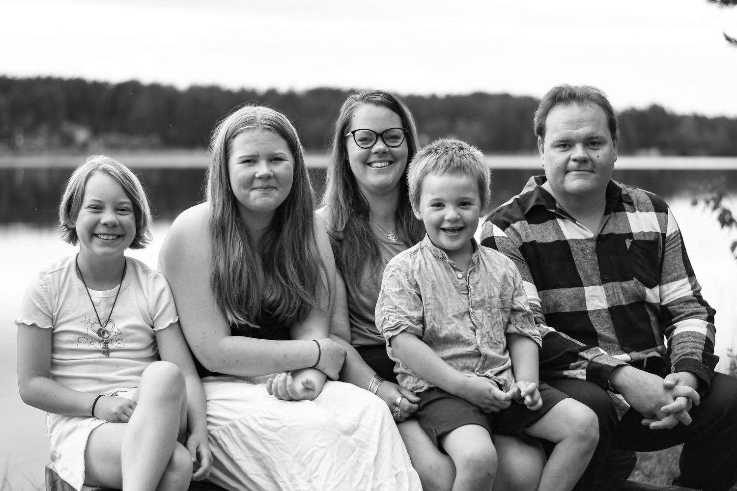 Familjemedlemmar kopplar av tillsammans vid en sjö på en solig dag.