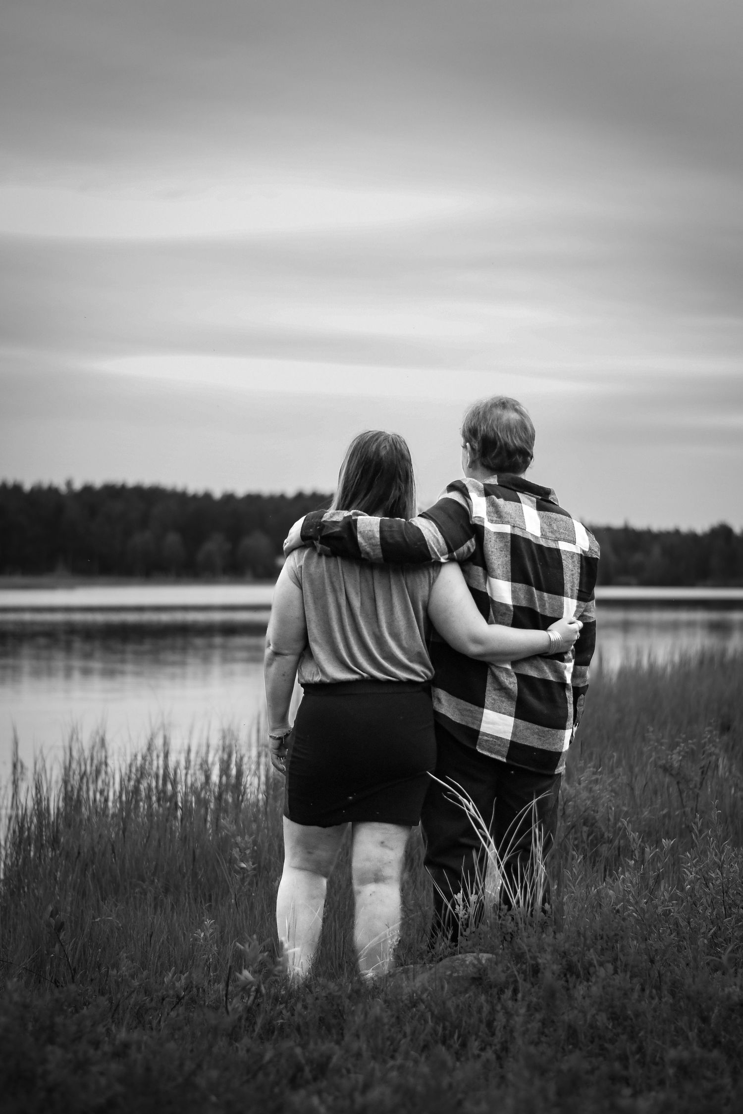 Deltagare vid formella evenemang poserar framför en bakgrund med gulddekorationer.
