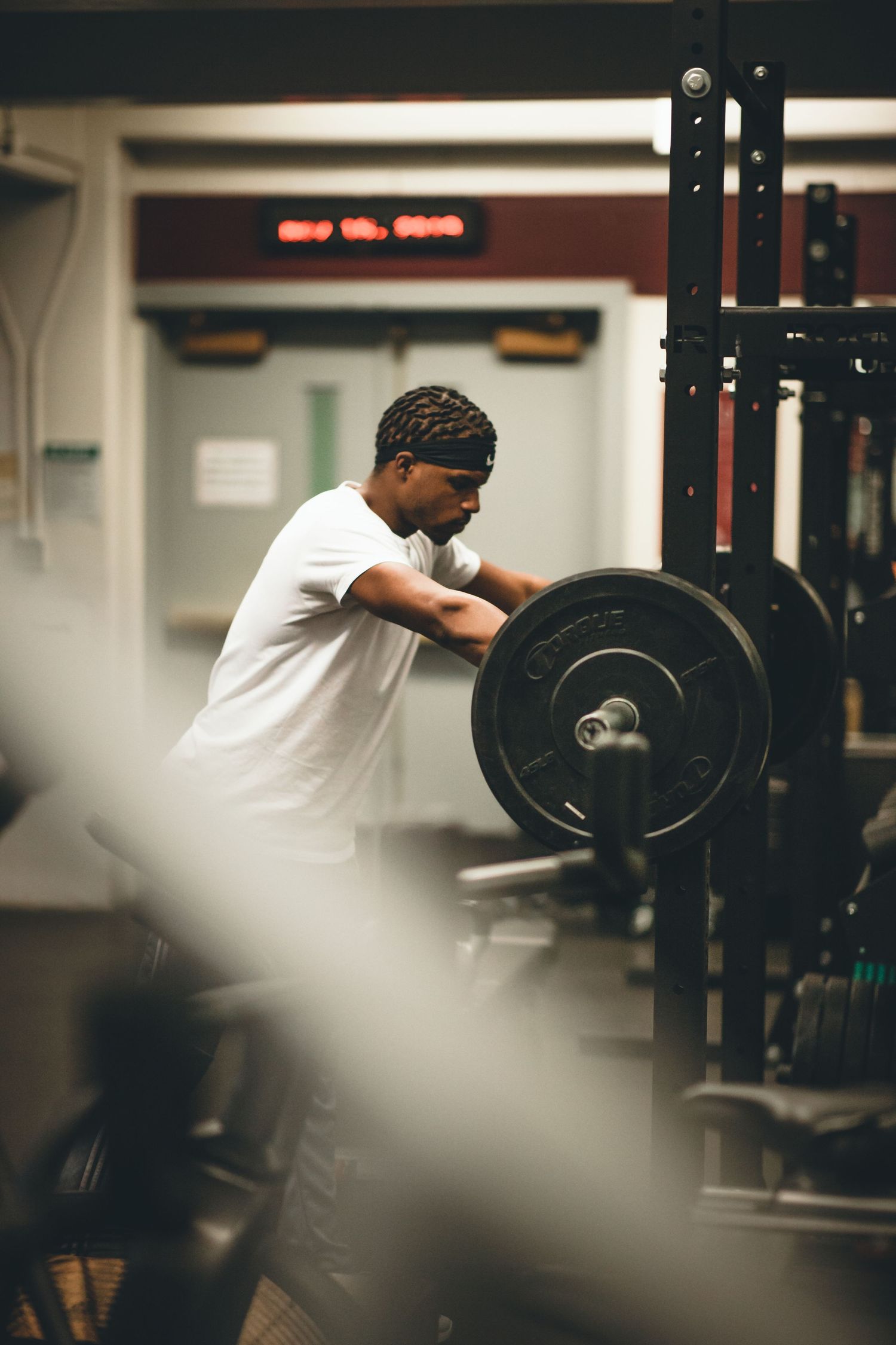 Series of strength training photos showing a person in white shirt performing barbell exercises at a gym.