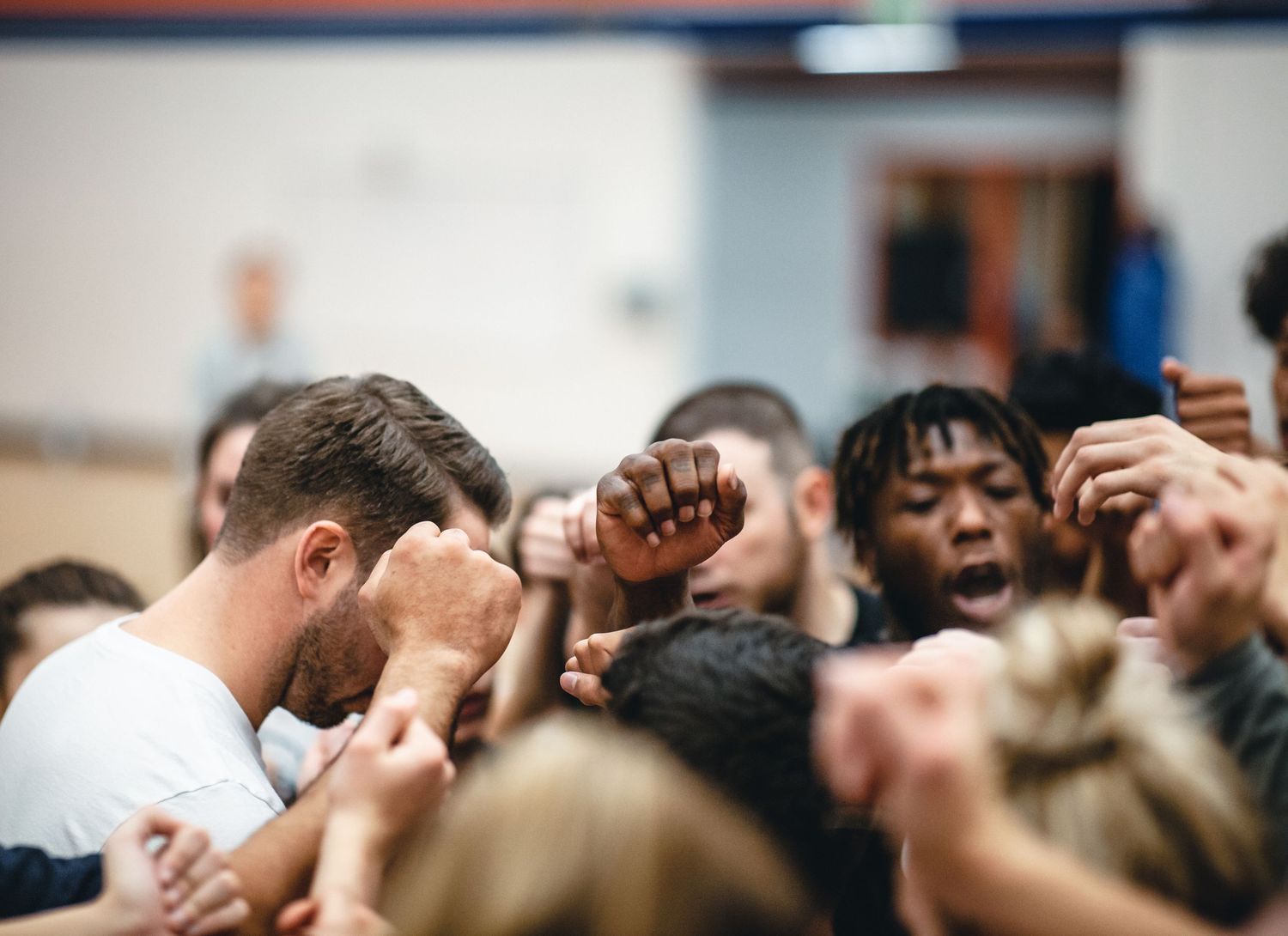 Team huddle with raised fists showing unity and team spirit.