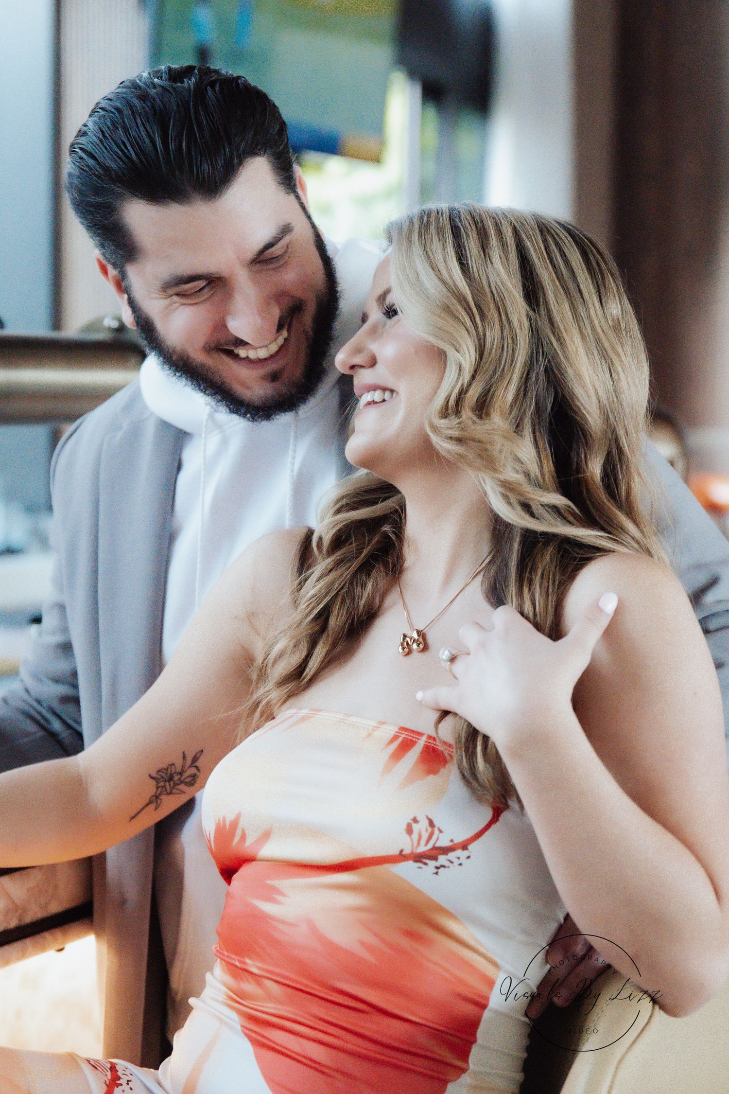 A candid moment of a couple laughing together in casual attire.