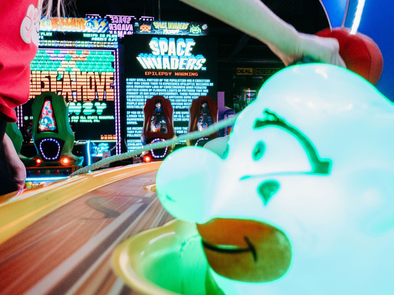 Child playing whack-a-mole style game at arcade.