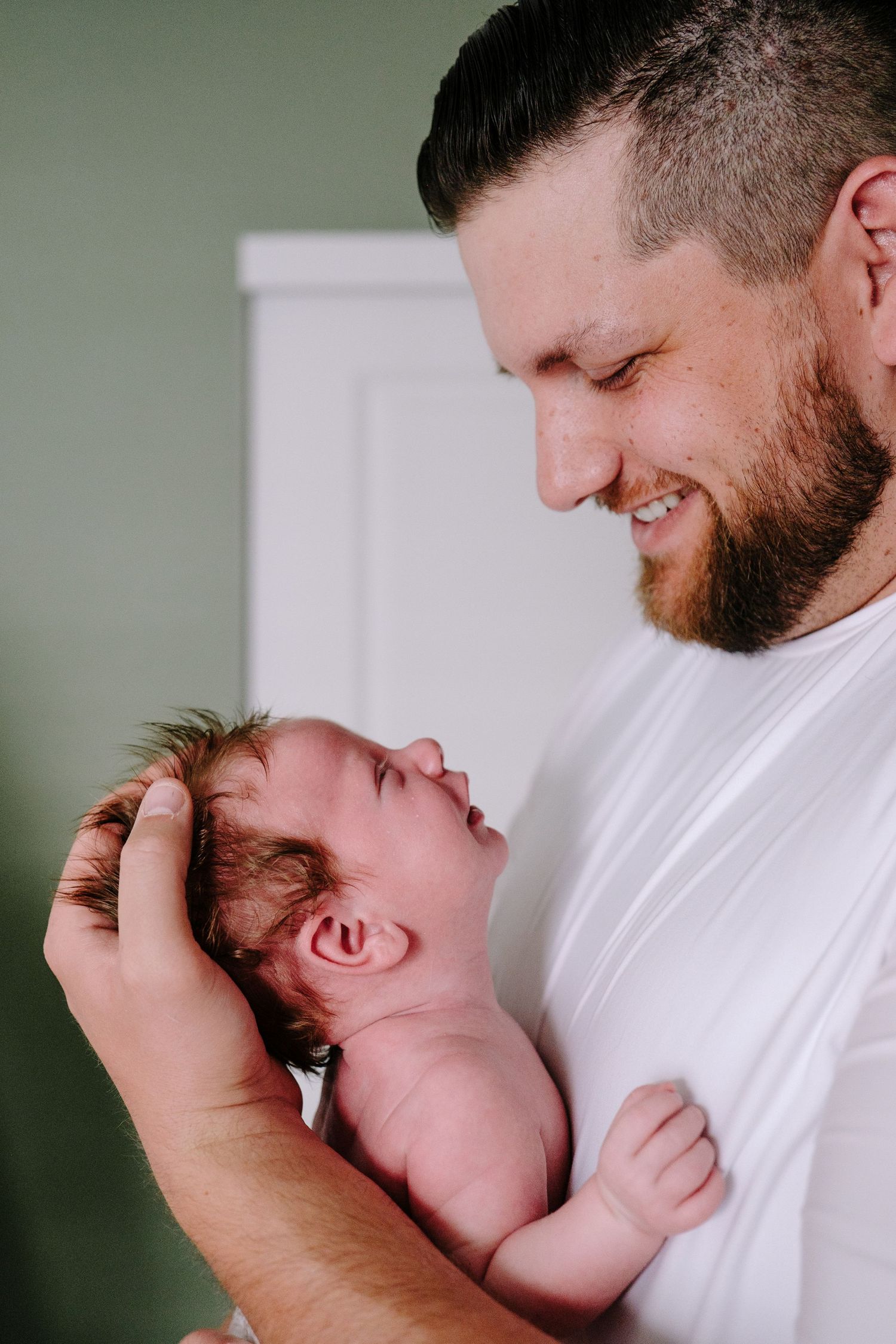 Close up of father peering down and son, son peering up at father.