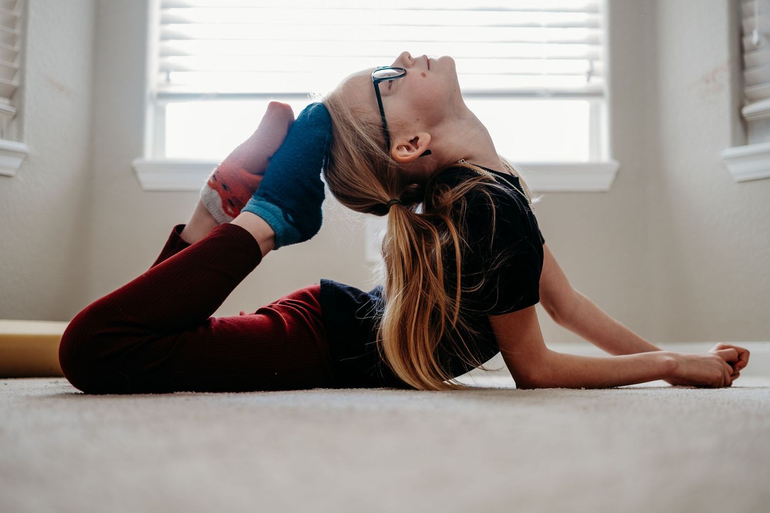 Denver photographer project 365 young girl on her stomach, touching her head to her toes in stretch