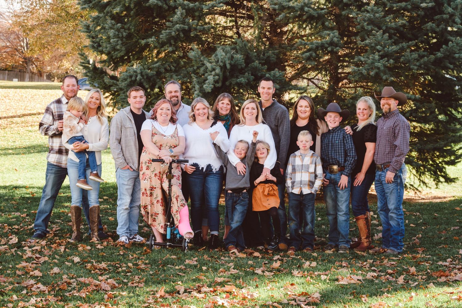Traditional, posed extended family standing together in neighborhood park in multi-generation photo session.