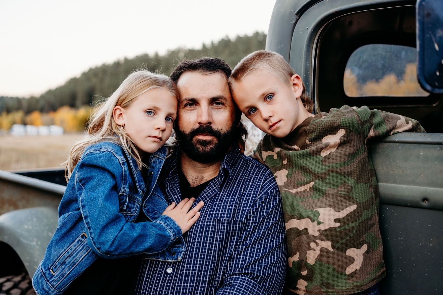 Father standing with daughter and son, all with serious expressions.