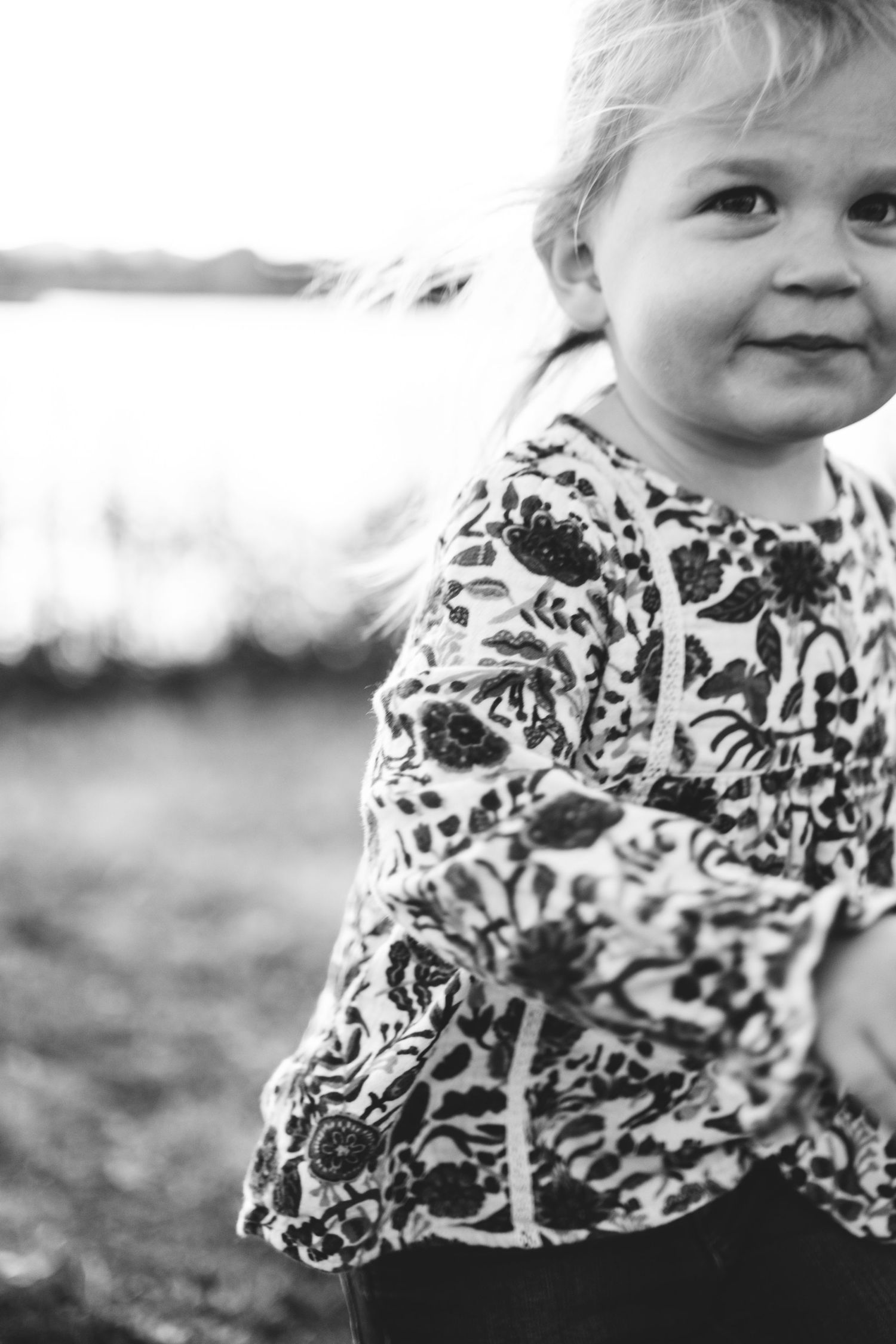 Black and white of toddler girl running, slight motion blur.