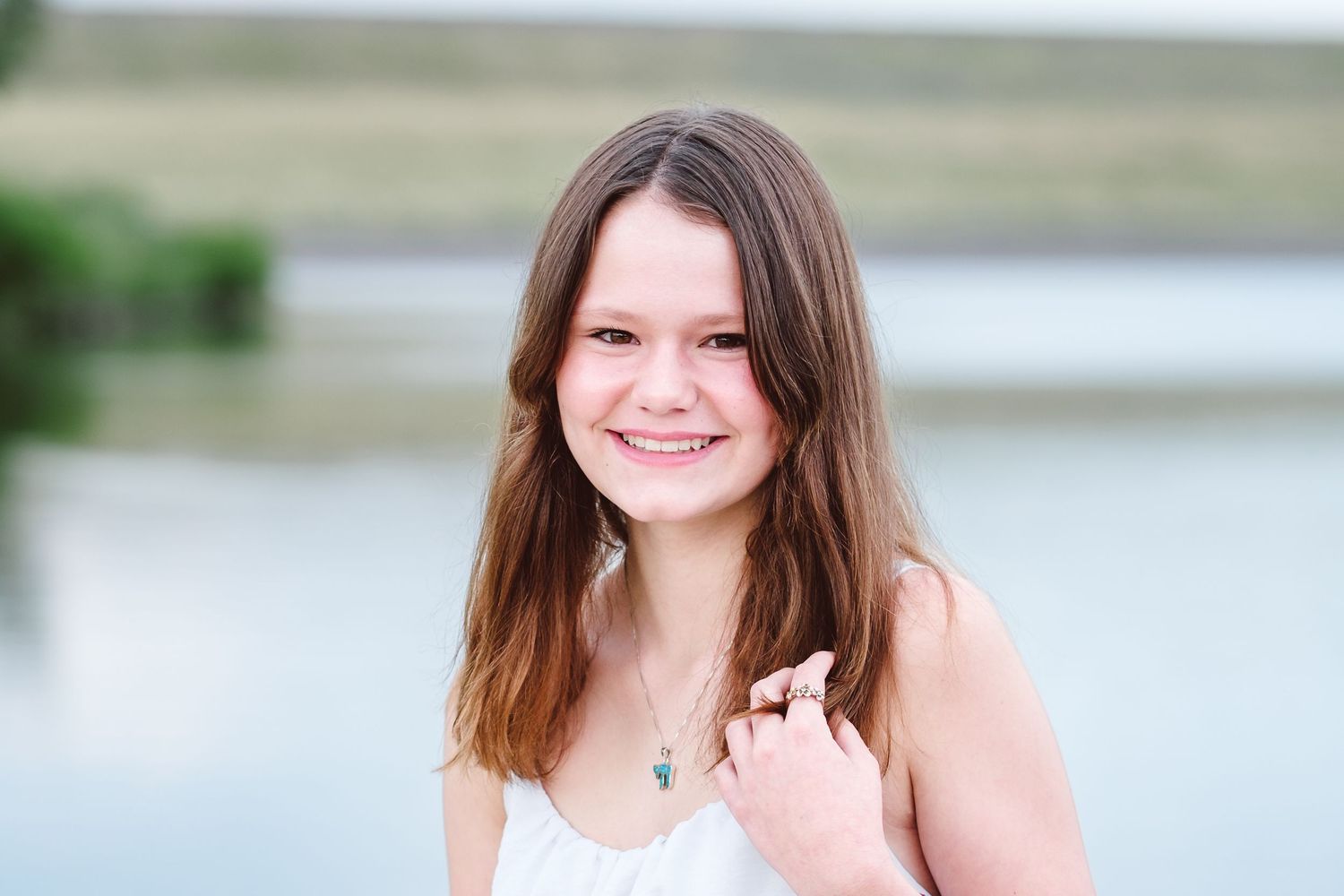 Teen girl standing in front of Bear Creek Lake in Lakewood, Colorado.