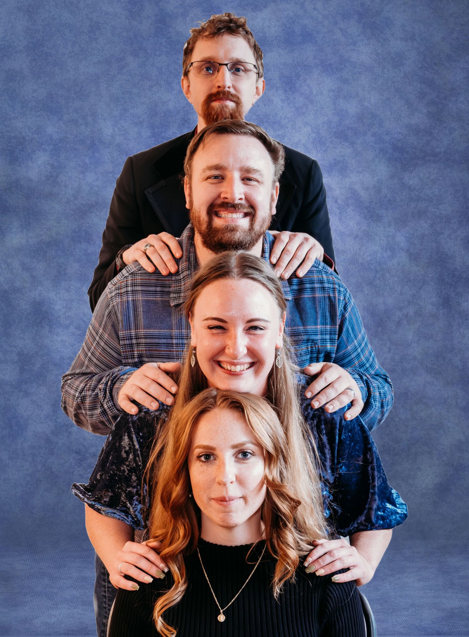 Playful, 1990s inspired awkward family photo of three adult siblings, all siblings stacked one on top of each other.