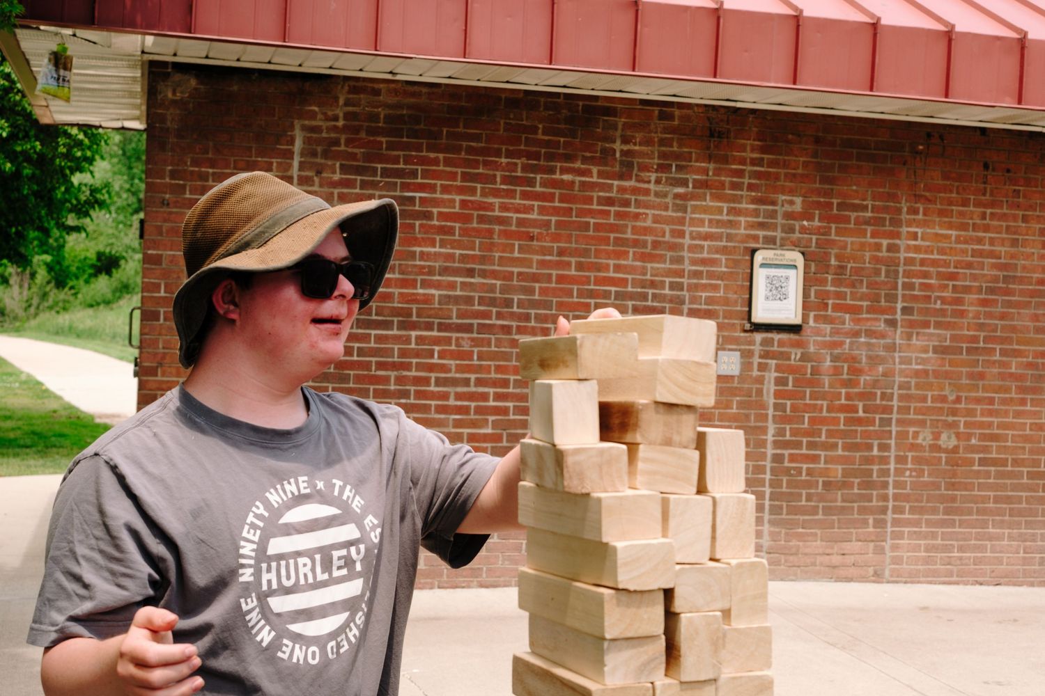 Young man playing oversized jenga.
