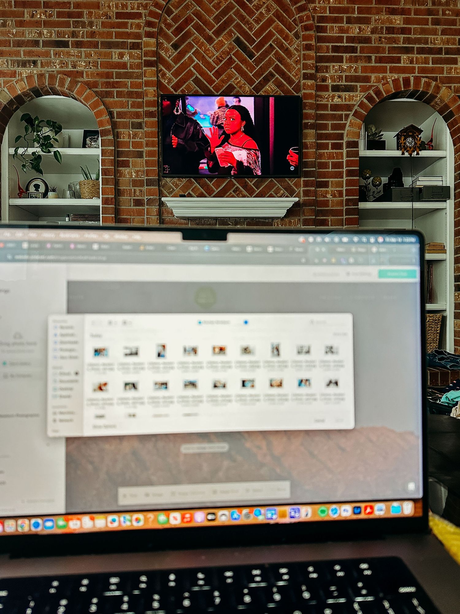 Computer screen visible, TV on in background.