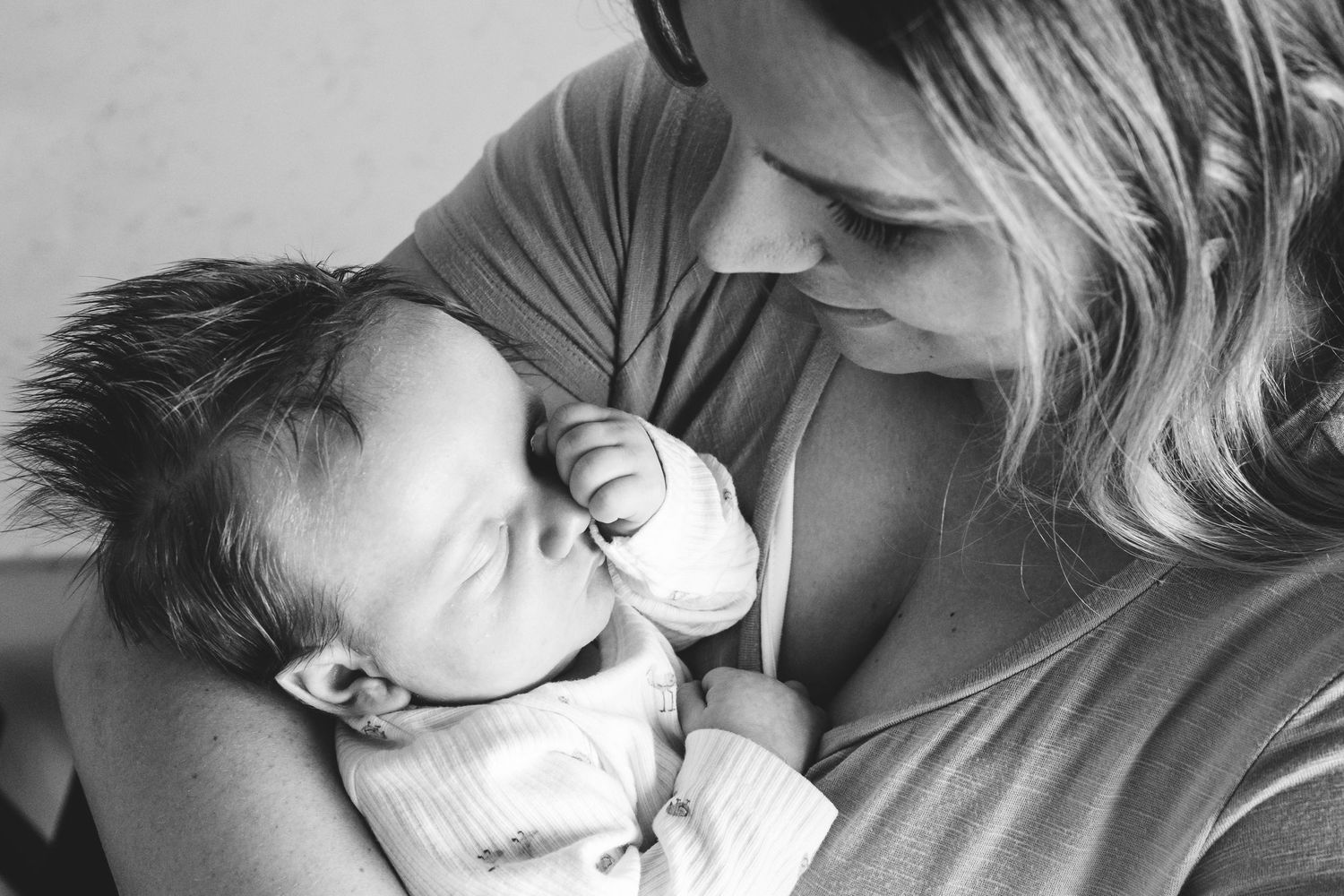 Black and white of mother holding newborn baby close.