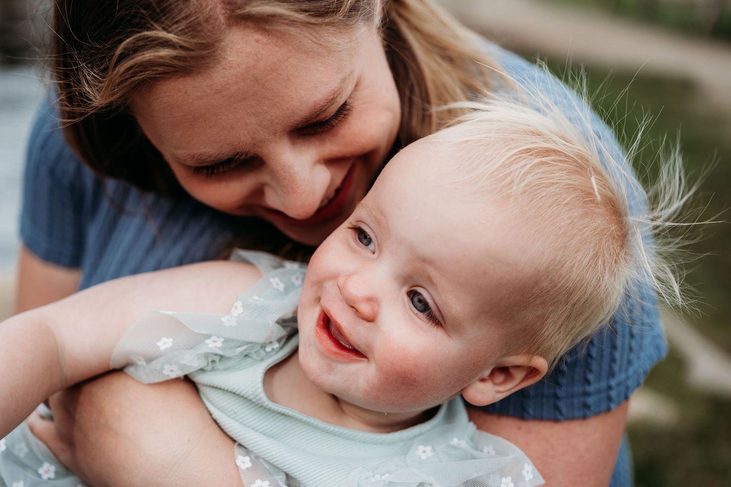 Close up of mother snuggling toddler daughter.