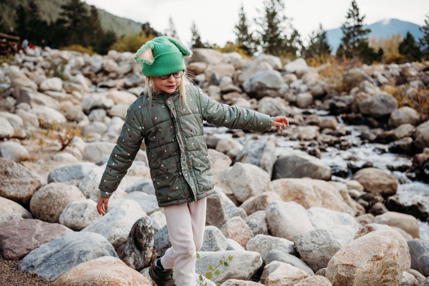 Young girl playing on rocks at Alluvial Fan in Rocky Mountain National Park.