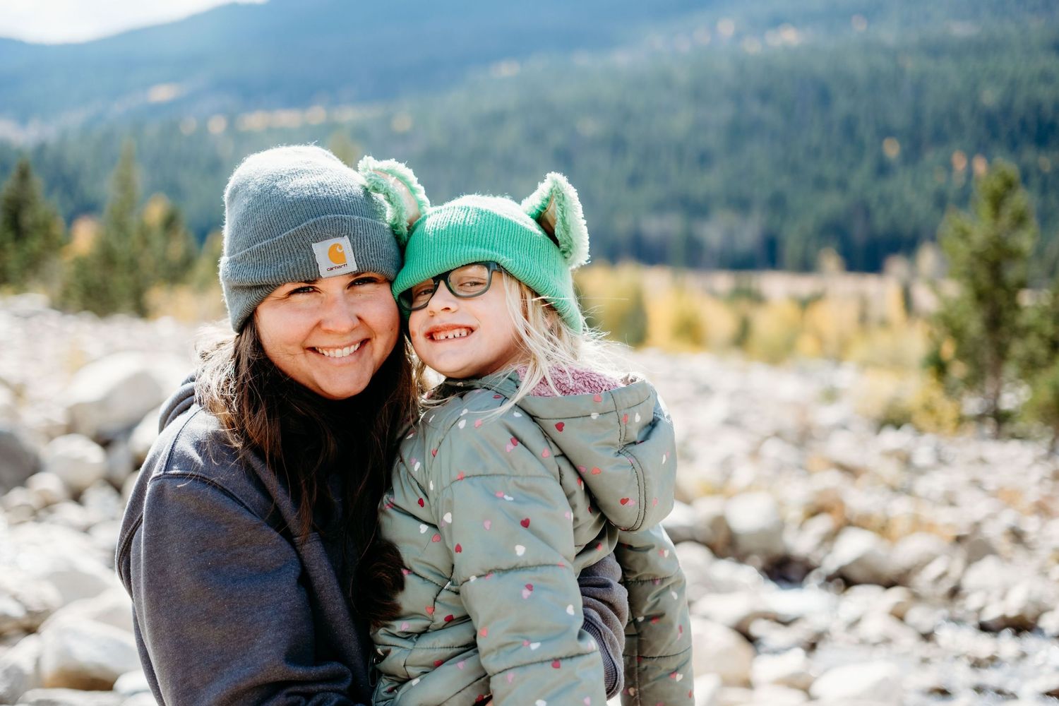 Mother holding girl at rocky area of Alluvial Fan in RMNP.
