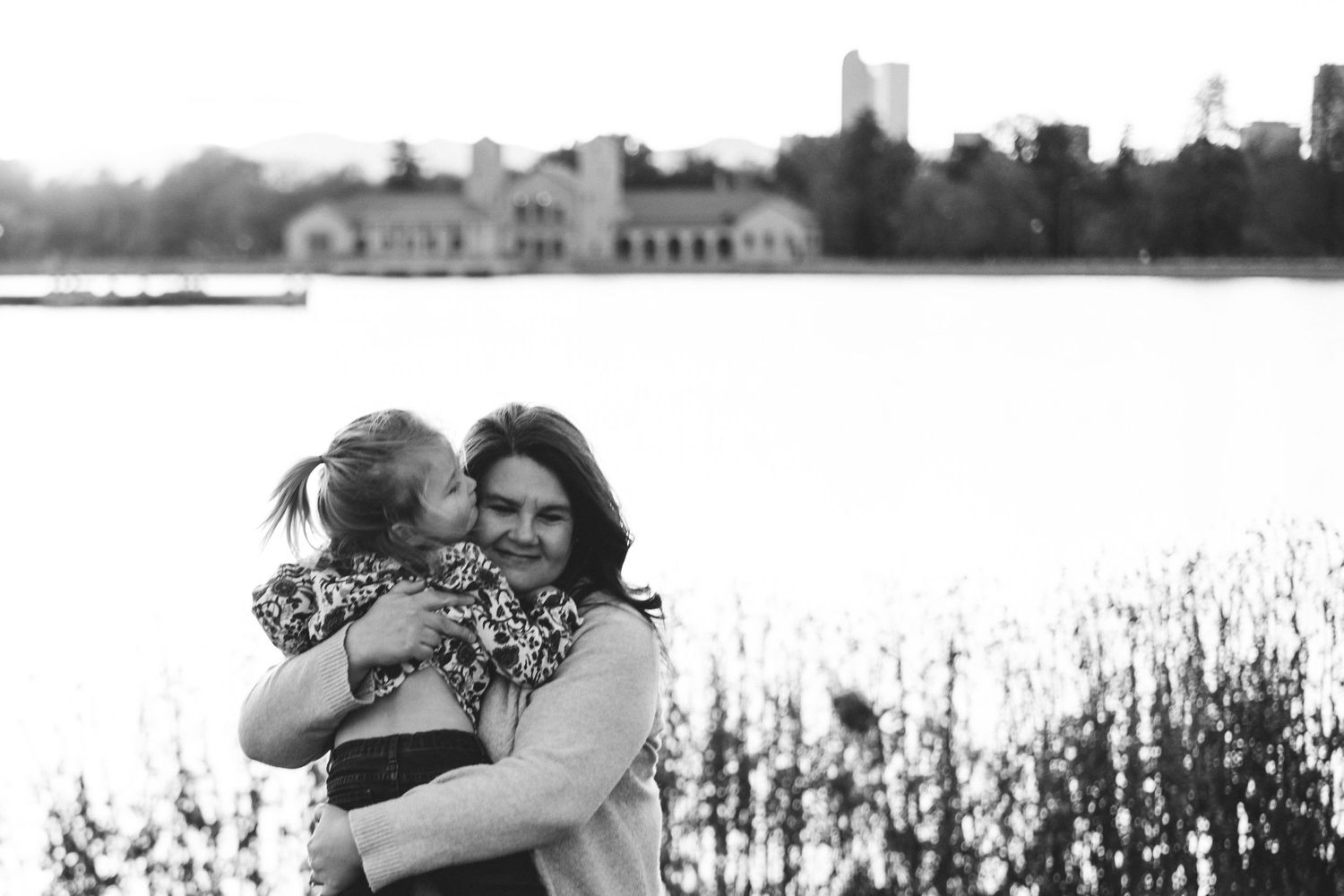 Black and white of mother holding toddler daughter closely.