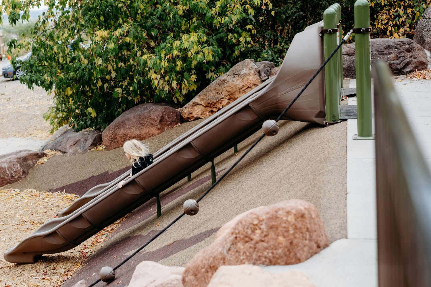 Young girl going down slide at Chataqua Park, Boulder.
