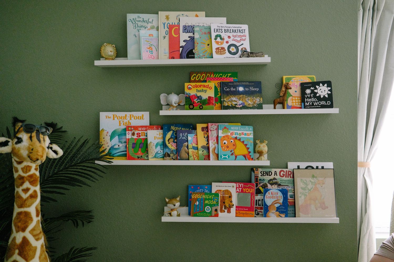 Book shelves in newborn nursery in home session, green wall.