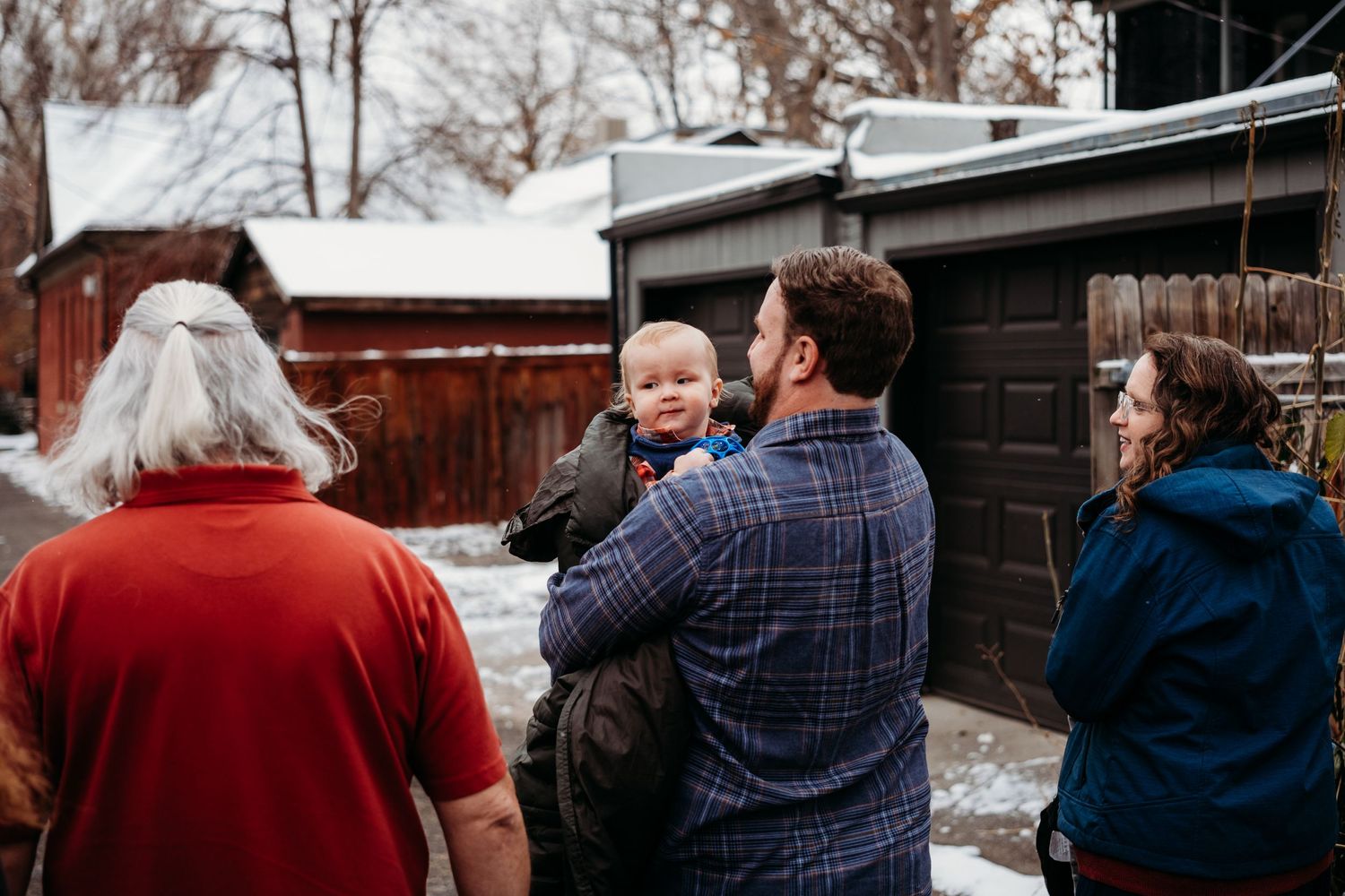 Documentary style photo of father carrying son walking in Denver alley.