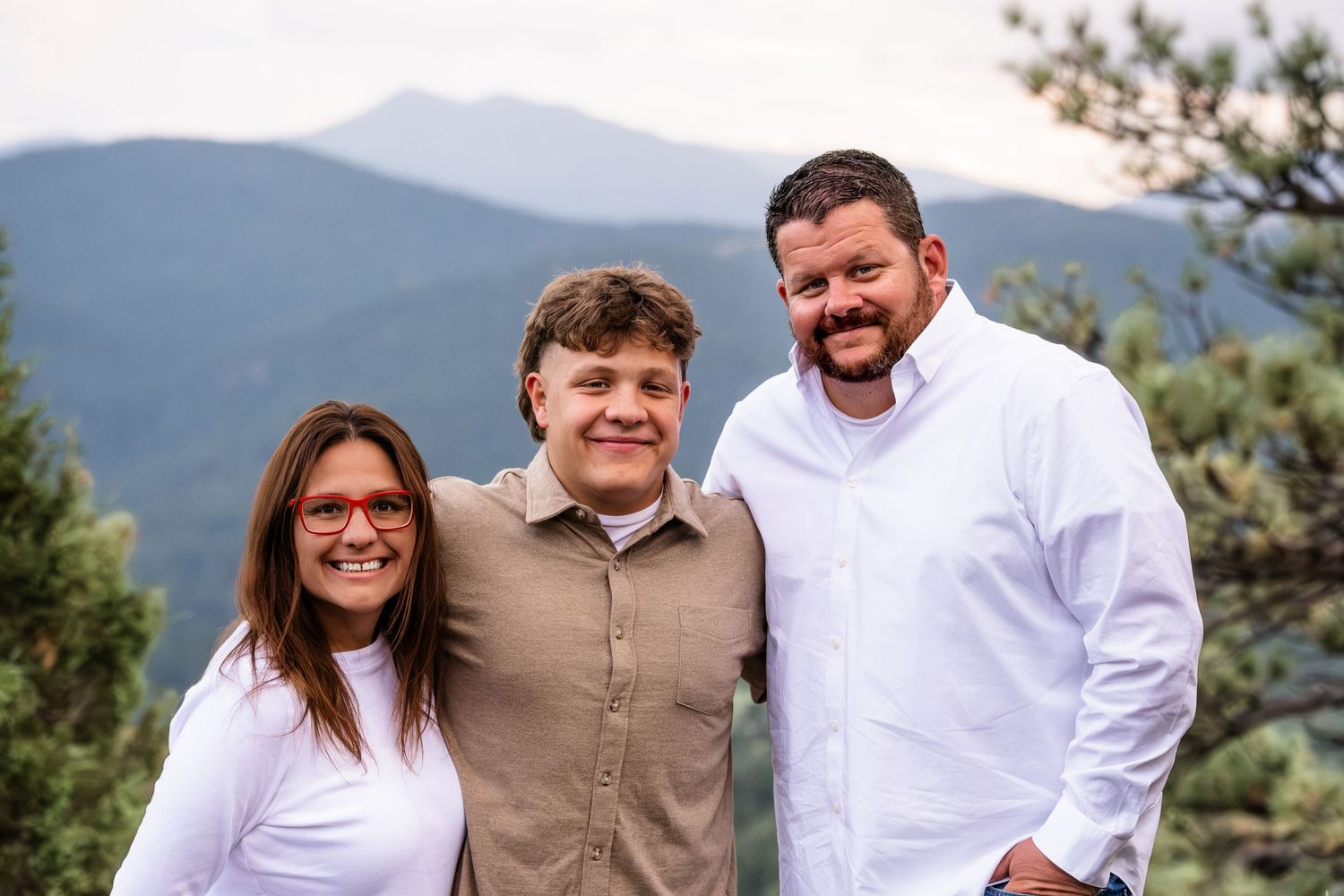 Mother, teen son and father smiling together at Mount Falcon West.