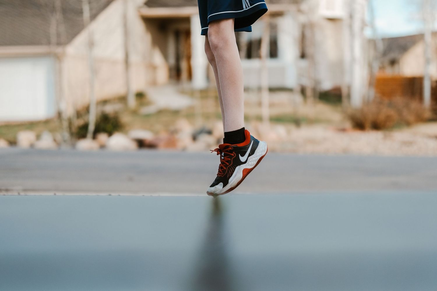 Boy on tiptoes, wearing nike shoes.