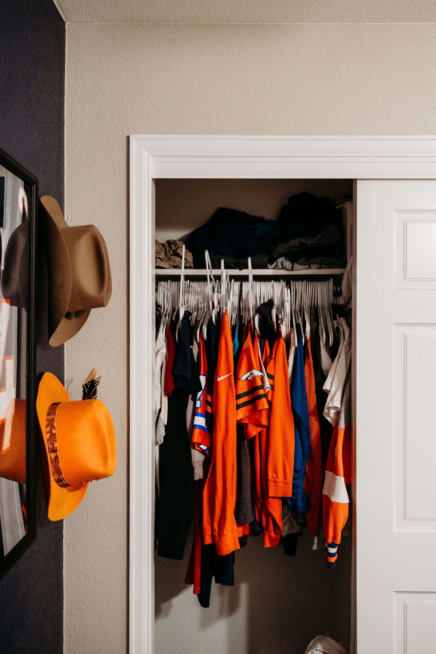 Closet full of orange broncos clothing.
